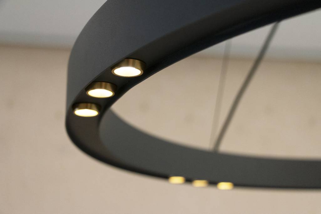 LedStore.fi:n valikoimaan kuuluva moderni pyöreä kattokruunu tummalla kehyksellä edustaa tyylikästä ja minimalistista muotoilua. Useat LED-valot on upotettu sisäreunaan, valaisten neutraalin taustan nykyaikaisella säväyksellä.